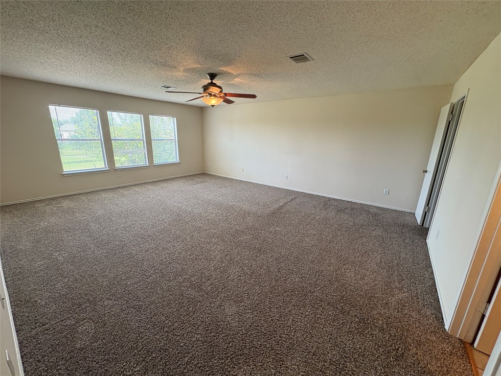 1367 Lakeside Loop Round Rock, TX 78665 - Photo 10 of 19 Carpeted empty room featuring a textured ceiling and ceiling fan