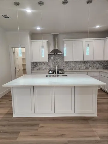 a kitchen with kitchen island white cabinets and stainless steel appliances