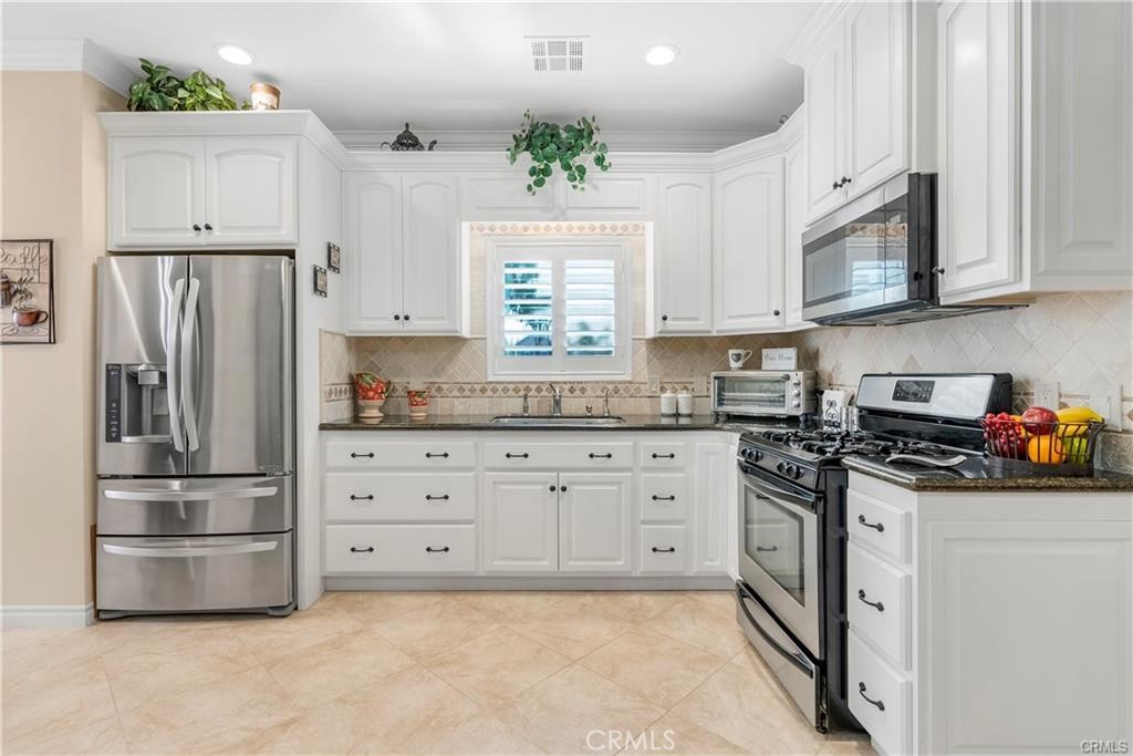 14222 Ashton Lane Riverside, CA 92508 - Photo 2 of 13 a kitchen with cabinets stainless steel appliances and a window