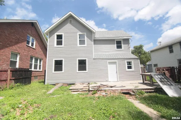 a front view of house with yard and outdoor seating