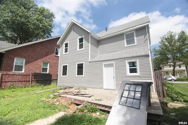 a view of a house with a yard and sitting area