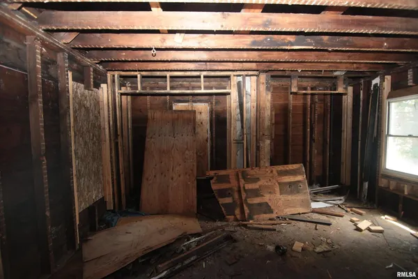 a room with water heater and wooden cabinets