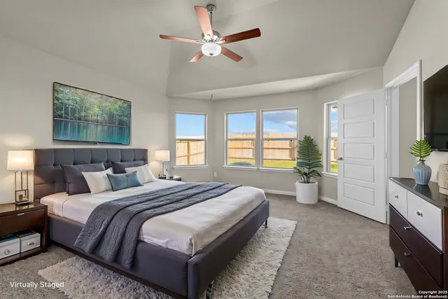 a spacious bedroom with a bed a dresser and a window