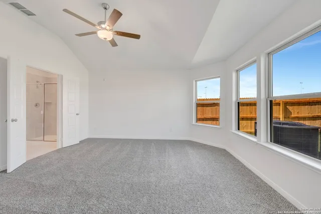 an empty room with windows and fan