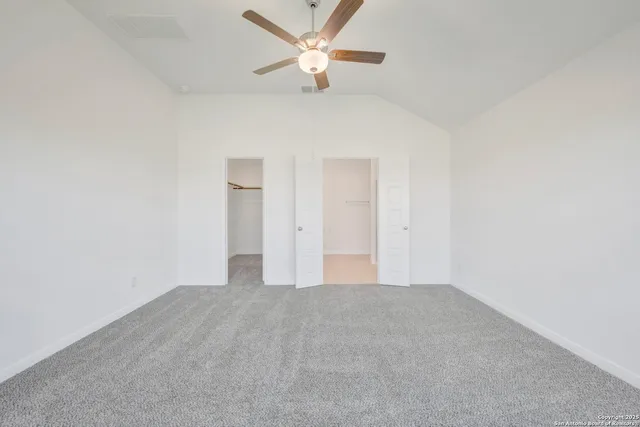 a view of an empty room and a ceiling fan