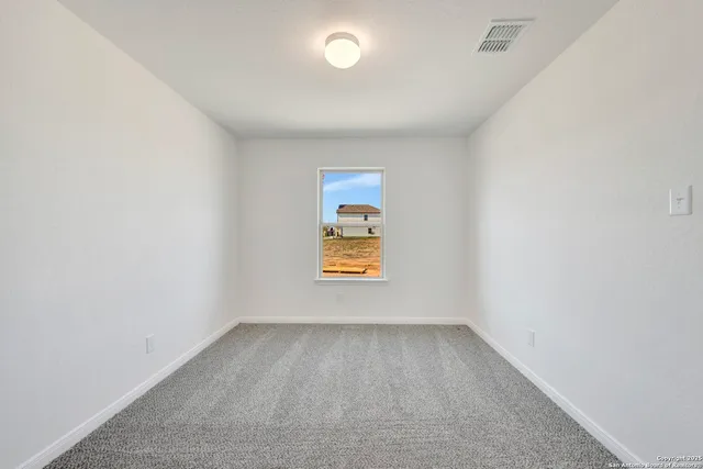 an empty room with a window and mirror
