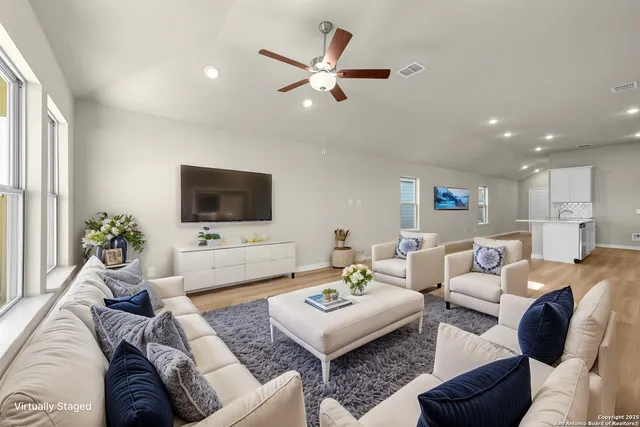 a living room with furniture a flat screen tv and a window