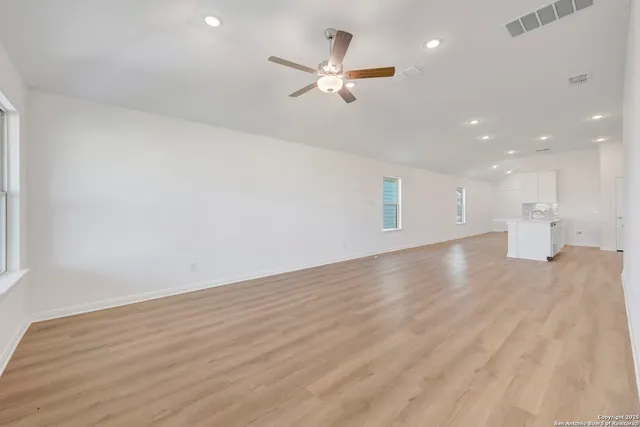 a view of an empty room with a ceiling fan