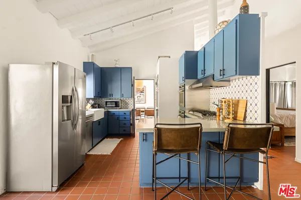 a kitchen with stainless steel appliances a refrigerator and wooden cabinets