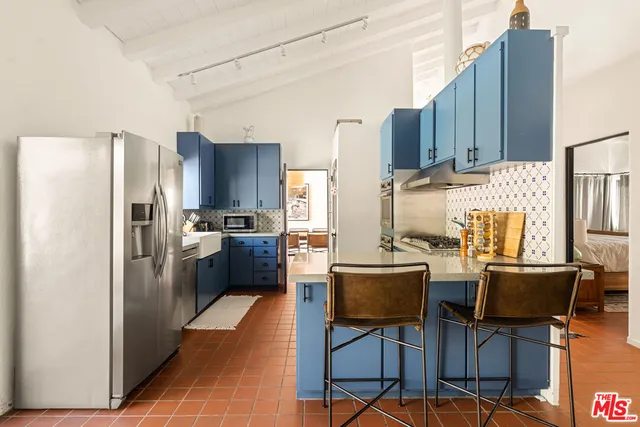 a kitchen with stainless steel appliances a refrigerator and wooden cabinets