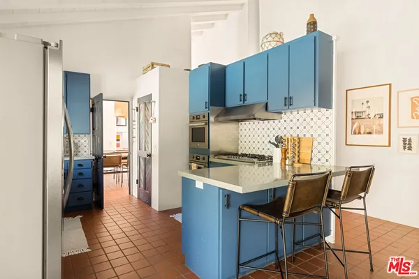 a kitchen with granite countertop a refrigerator and a stove top oven