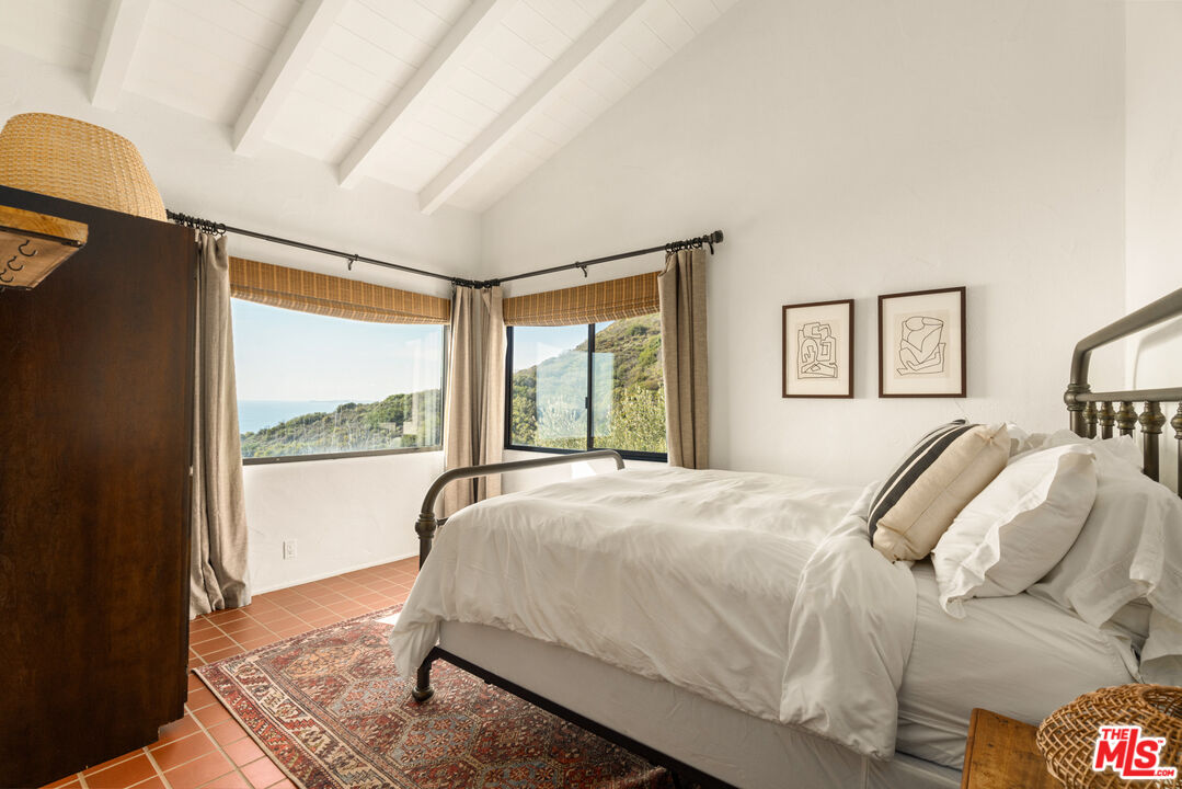 20755 Seaboard Road Malibu, CA 90265 - Photo 23 of 57 a bed sitting in a bedroom next to a window