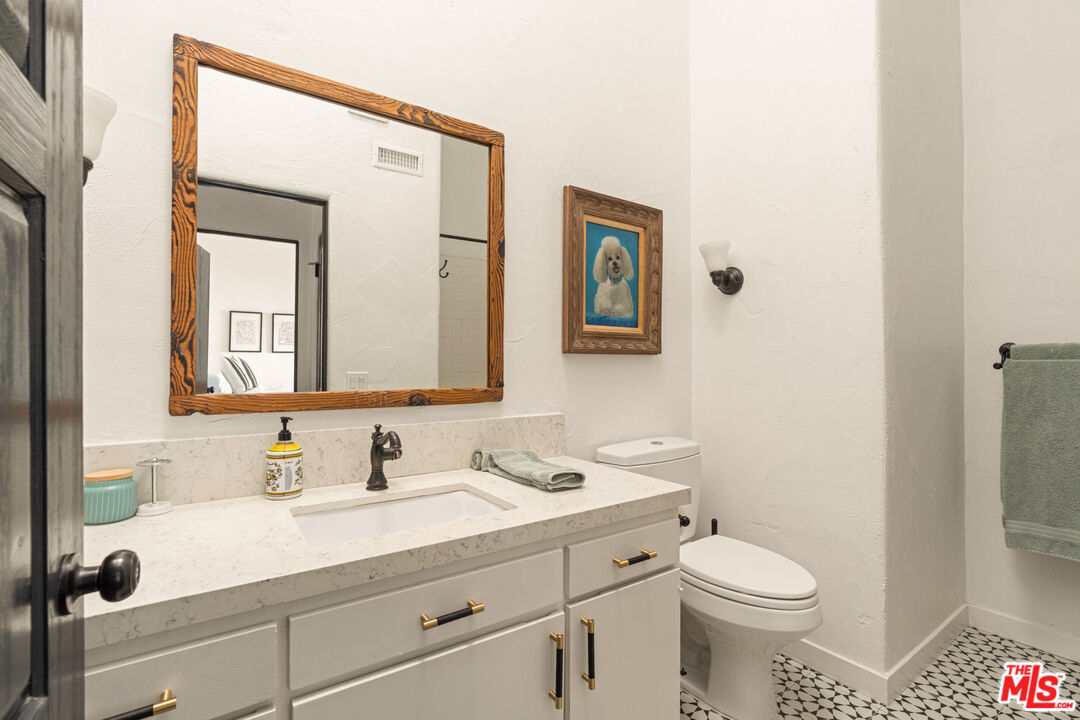 20755 Seaboard Road Malibu, CA 90265 - Photo 24 of 57 a bathroom with a granite countertop sink mirror vanity and toilet