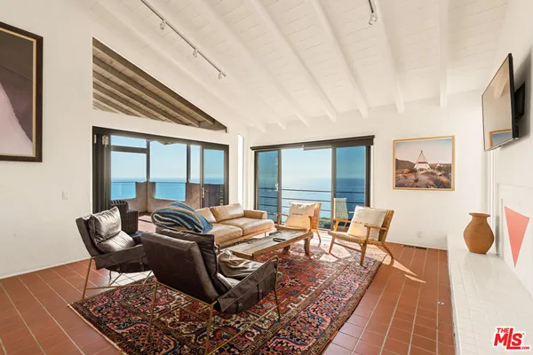 a living room with furniture and a floor to ceiling window