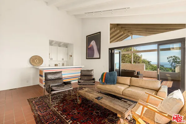 a living room with furniture and a floor to ceiling window