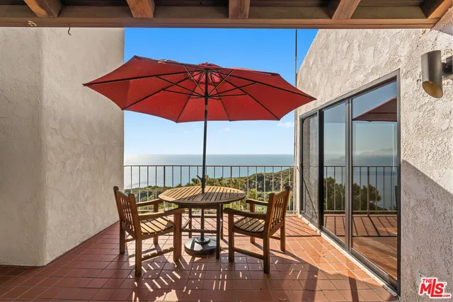 a view of a patio with table and chairs under an umbrella