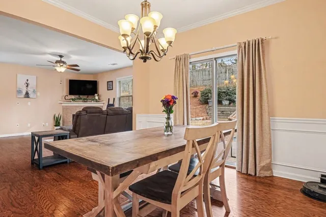 a view of a dining room with furniture wooden floor and chandelier