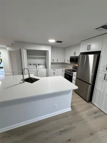 a kitchen with stainless steel appliances a refrigerator sink and microwave