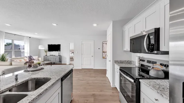 a kitchen with stainless steel appliances granite countertop a sink and a stove