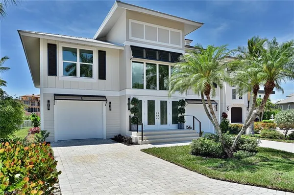 a front view of a house with a yard and trees