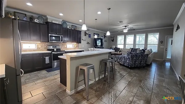 a kitchen with kitchen island a sink stainless steel appliances and cabinets
