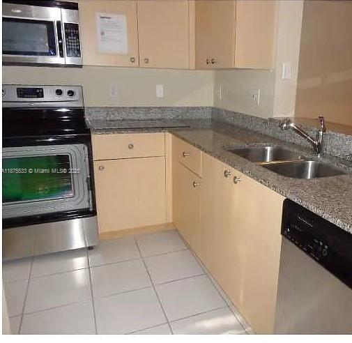 2516 Centergate Drive, Unit 308 Miramar, FL 33025 - Photo 2 of 16 a kitchen with granite countertop a stove top oven and cabinets