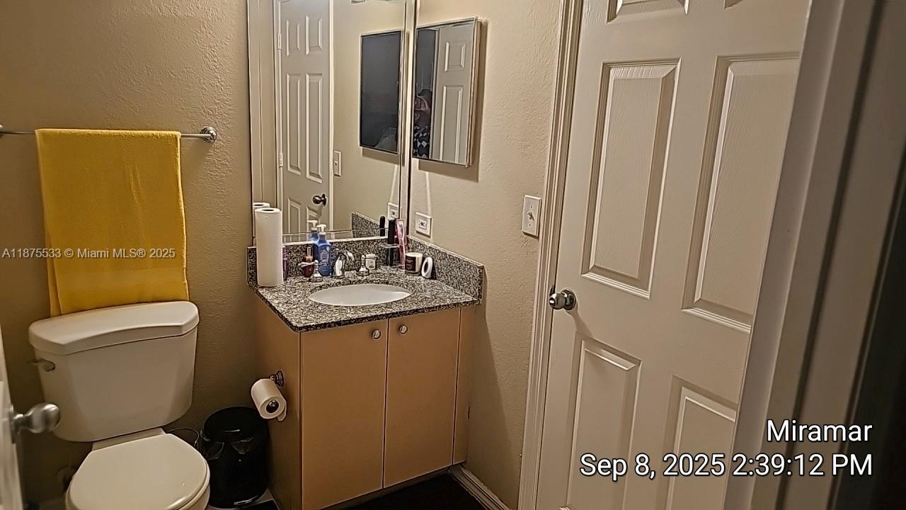 2516 Centergate Drive, Unit 308 Miramar, FL 33025 - Photo 8 of 16 a bathroom with toilet sink and mirror