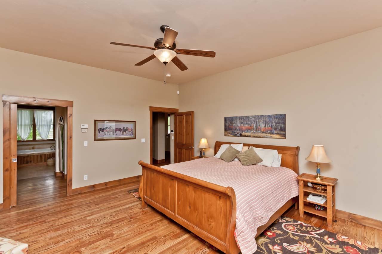 1355 Saddle Ridge Road Loma, CO 81524 - Photo 10 of 36 a bedroom with a bed and wooden floor