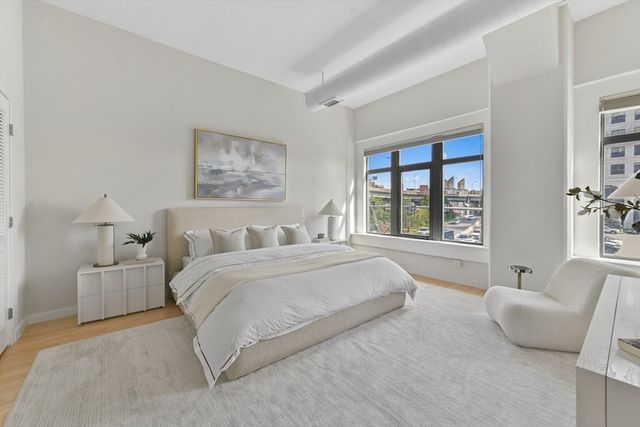 a spacious bedroom with a large bed and a large window