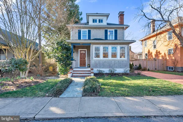 a front view of a house with a yard and trees