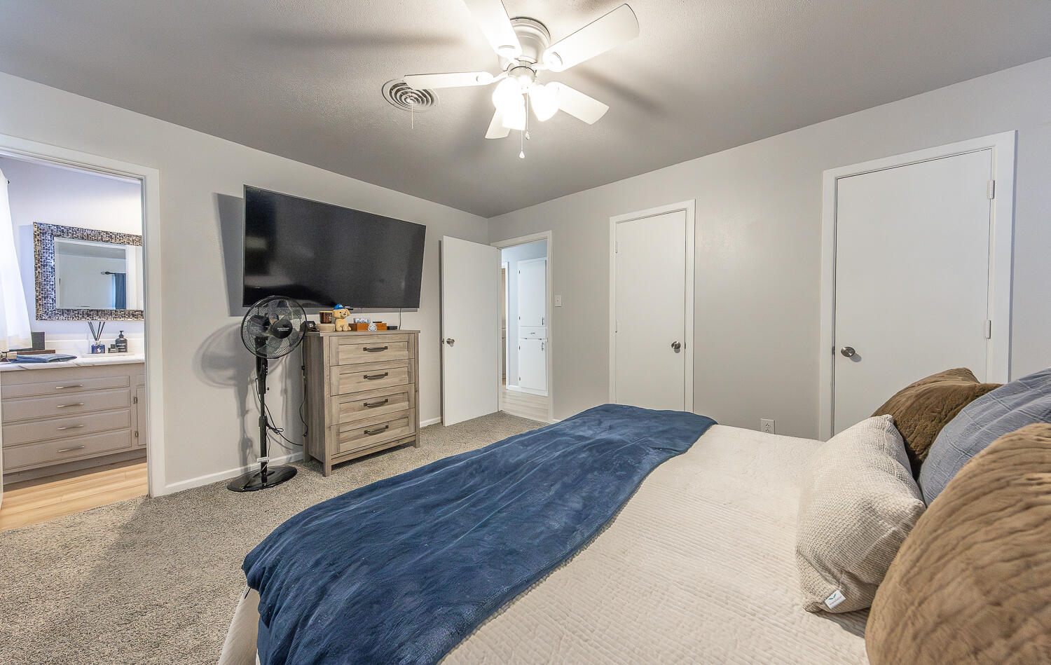 3613 58th Street Lubbock, TX 79413 - Photo 9 of 20 a bedroom with a bed and a flat tv screen on dresser