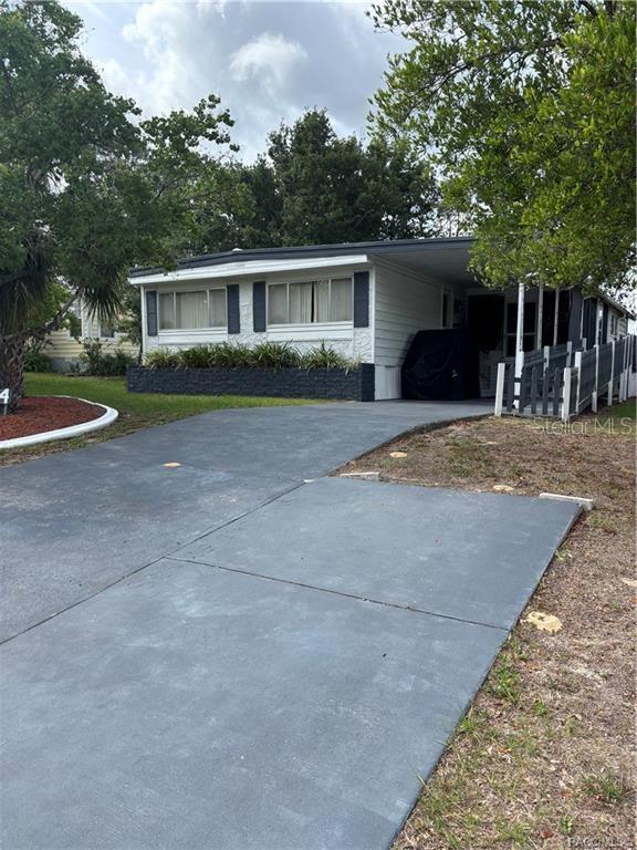 a front view of house with yard and trees in the background