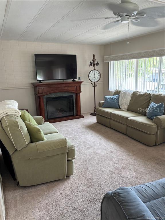 14334 Midfield Street Brooksville, FL 34613 - Photo 14 of 48 a living room with furniture a flat screen tv and a fireplace