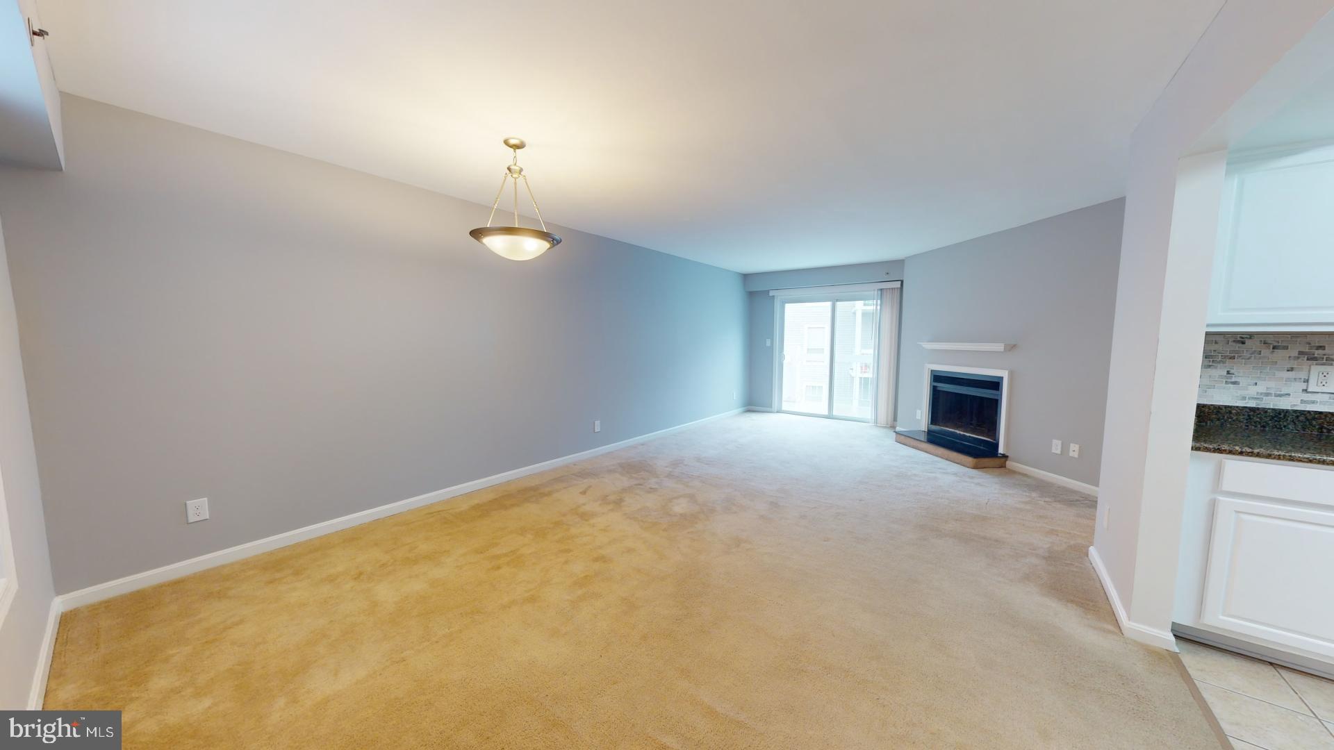 a view of a livingroom with an empty space and a fireplace