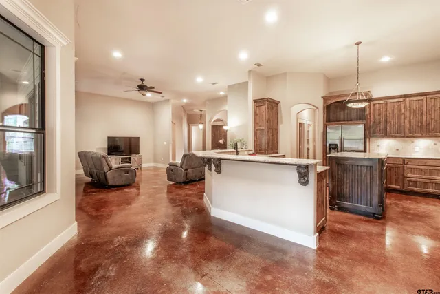 a kitchen with kitchen island granite countertop a sink stove and refrigerator
