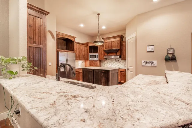 a kitchen with stainless steel appliances granite countertop a stove and a sink