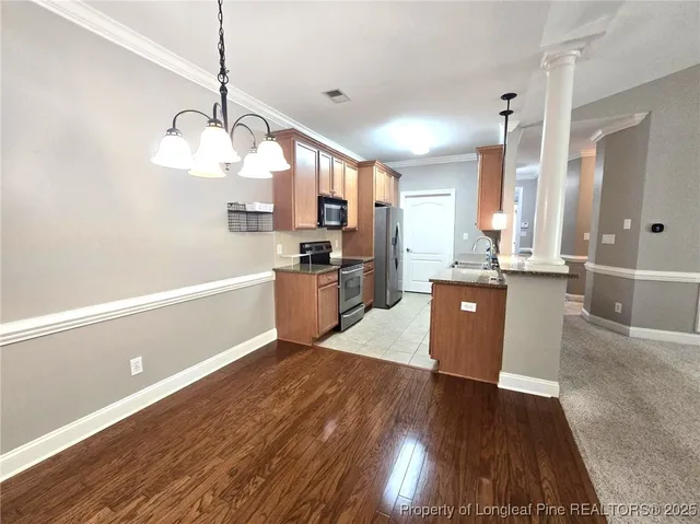 a open kitchen with cabinets a stove and a wooden floors