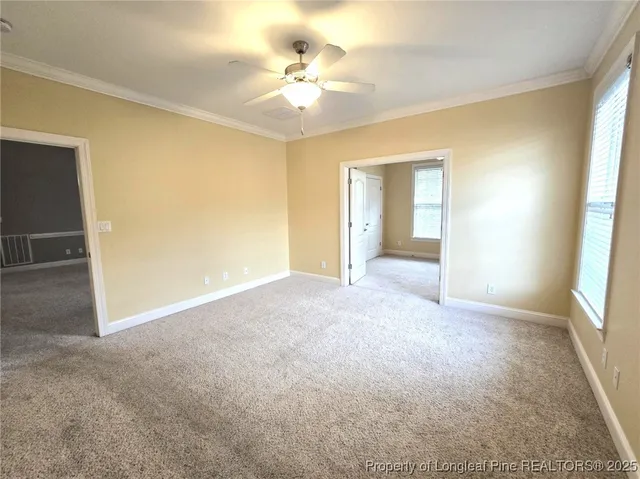 a view of a big room with windows and chandelier fan