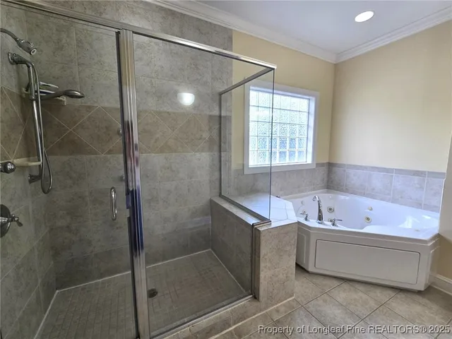 a bathroom with a bathtub a shower and a window