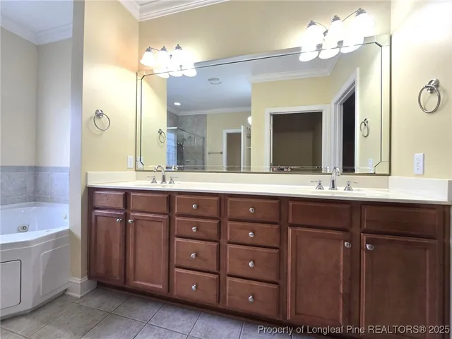 a bathroom with a granite countertop double vanity sink and a large mirror