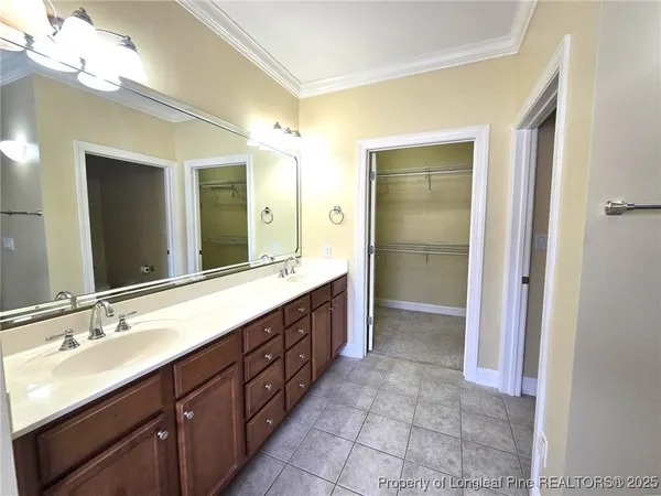 a spacious bathroom with a double vanity sink a large mirror and a shower