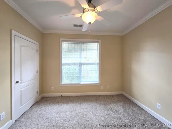 an empty room with a window and a fan