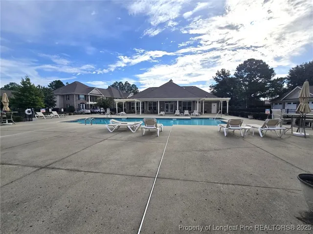 a swimming pool with outdoor seating and yard