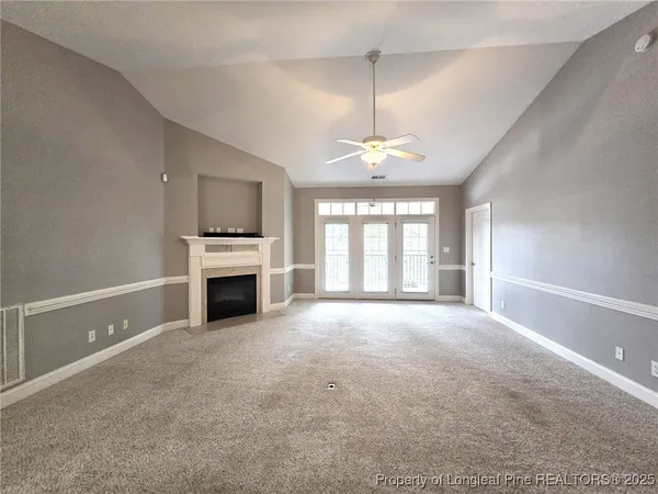 a view of an empty room with a fireplace and a window