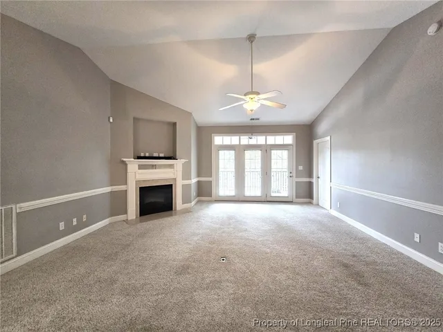 a view of an empty room with a fireplace and a window