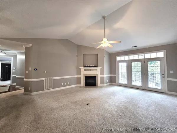 a view of an empty room with window and fire place