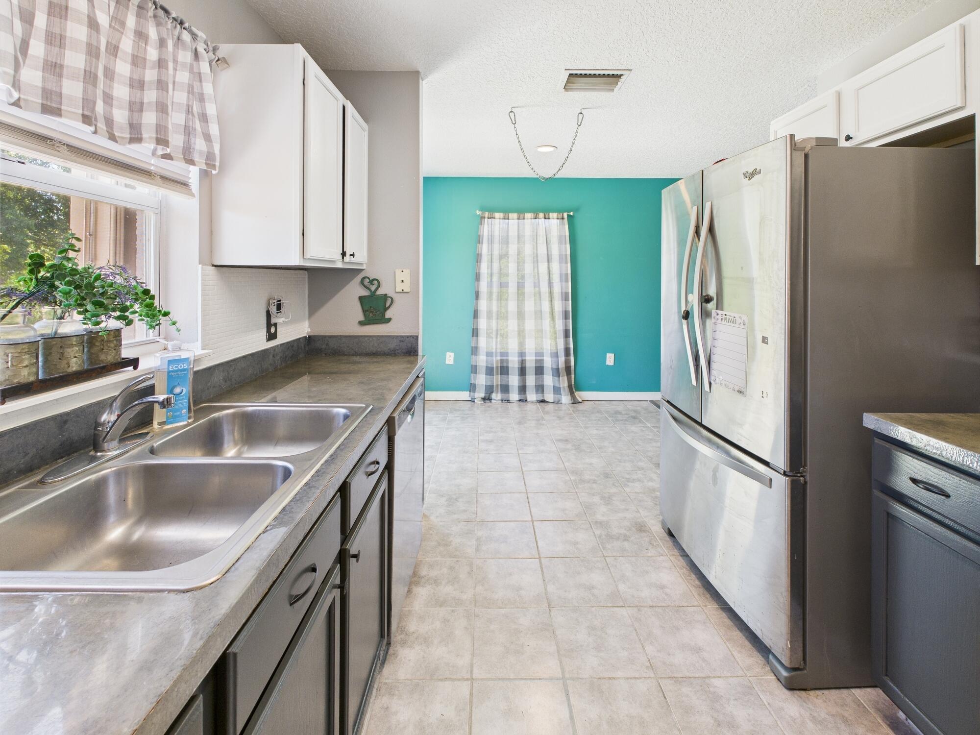 6504 Southeast 86th Boulevard Okeechobee, FL 34974 - Photo 12 of 38 a kitchen with granite countertop a refrigerator and a sink
