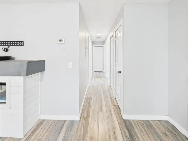 a view of a hallway with wooden floor