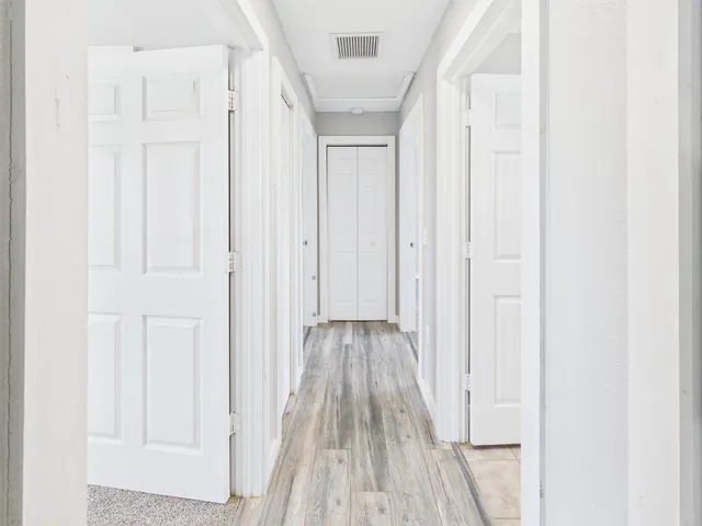 a view of a hallway with wooden floor