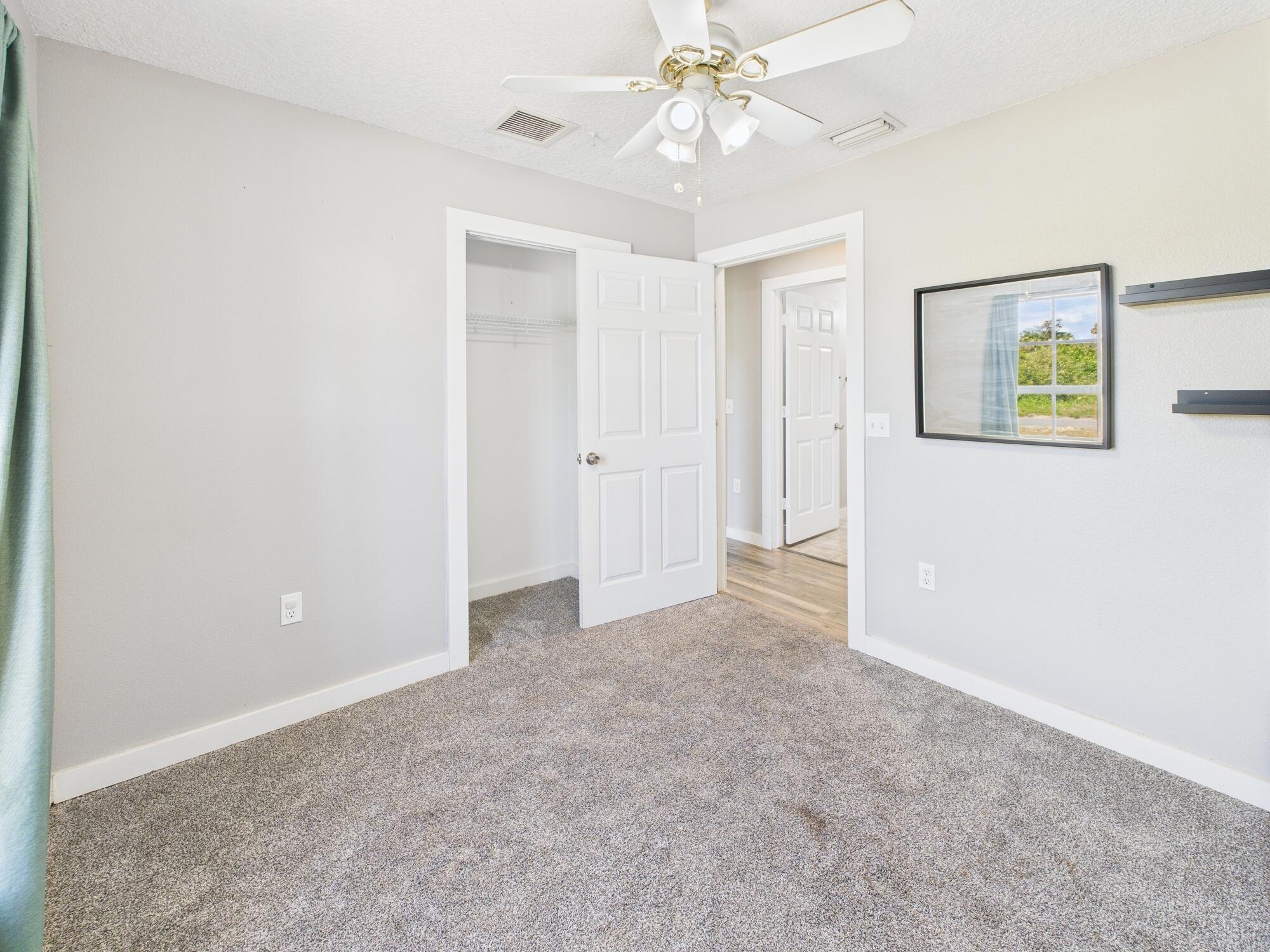 6504 Southeast 86th Boulevard Okeechobee, FL 34974 - Photo 20 of 38 an empty room with a chandelier fan and closet